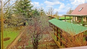 Ein Haus mit einem grünen Dach, einer überdachten Veranda und Blick auf einen See.