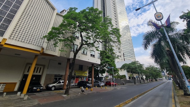 A street view with tall buildings, parked cars, and a clear sky. - 407 Moderno Aparta-Suite en Versalles Tipo Loft - Cali Tower Suites & Lofts (Cali)
