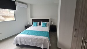 A bedroom with a bed, two nightstands, a window, and a wardrobe. - 407 Moderno Aparta-Suite en Versalles Tipo Loft - Cali Tower Suites & Lofts (Cali)