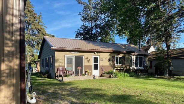 A two-story house with a front porch, a garage, and a well-maintained lawn. - All Season Fully Furnished Home (Waskish)