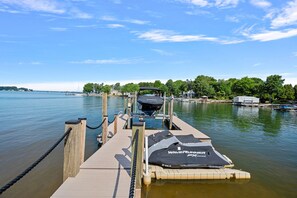 A wooden dock extending into calm water with a boat and a canopy labeled "Waverunner FX3" on the dock.