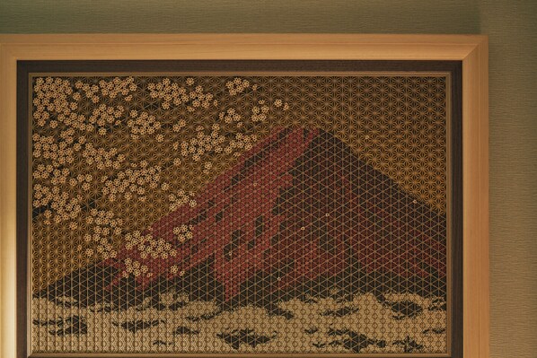 A framed artwork with a geometric pattern and a mountain-like structure.