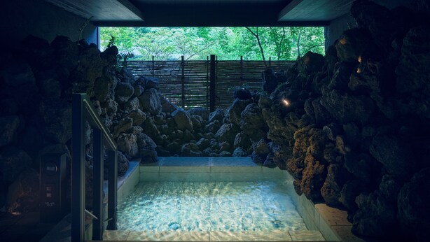 A hot spring area with a stone wall and wooden fence, a wooden deck, and a view of greenery outside. - ESPACIO The Hakone Geihinkan Rin-Poh-Ki-Ryu (Hakone)