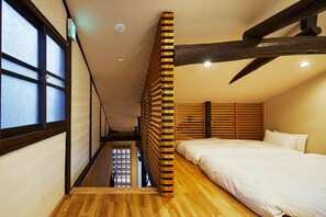 Cozy loft-style bedroom with a single bed and a unique ladder leading to a space with an outside view.