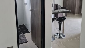 Una cocina moderna con comedor, horno empotrado y un taburete negro.
