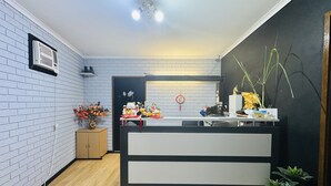 Una cocina moderna con un revoque blanco, un mueble de madera, encimera negra y blanca y un ventilador de techo.
