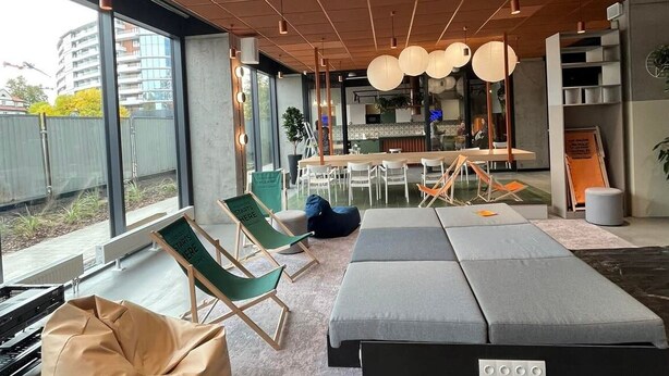Un intérieur moderne comprenant un coin repas, des espaces de détente et de grandes fenêtres offrant une vue sur l’extérieur.