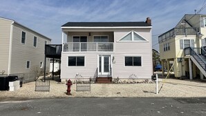 A two-story house with a balcony, a fire hydrant, and a gravel driveway. - Sunset Cove: Bayview, fantastic location, close to everything (Long Beach)
