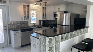 A modern kitchen with white cabinets, a stainless steel refrigerator, a microwave, and a dishwasher. - Sunset Cove: Bayview, fantastic location, close to everything (Long Beach)