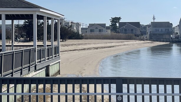 A beach view with a covered walkway and a sandy beach. - Sunset Cove: Bayview, fantastic location, close to everything (Long Beach)