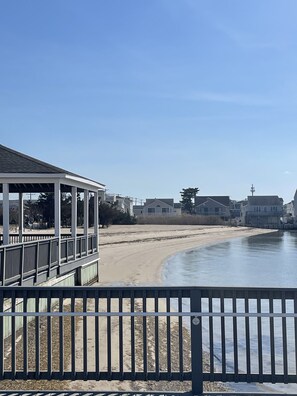 A beach view with a covered walkway and a sandy beach. - Sunset Cove: Bayview, fantastic location, close to everything (Long Beach)