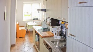 A compact kitchen with a dining area, a window, and a refrigerator. - Amazing apartment in Klink with WiFi (Klink)
