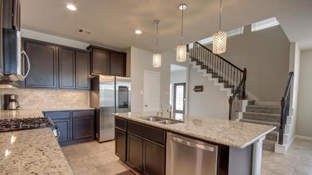 A modern kitchen with granite countertops, stainless steel appliances, and dark cabinetry. - Roseberg/Suglarland  3-BR - Extended Stay 30 days  (Rosenberg)