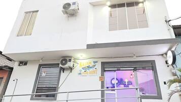 Un edificio de dos pisos con un letrero que dice 'Kayak for Rent' y 'Poseidon Lodging' en la planta baja.
