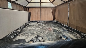 A hot tub with a glass ceiling, surrounded by beige walls and curtains. - Balsam Retreat- Muskoka Getaway
Pet Friendly (Huntsville)