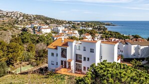 A coastal residential area with modern white buildings, some with balconies, and a view of the sea. - Sant Genis 19.2 Top floor apartment with terrace (Llança)