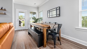 A modern dining area with a wooden table, black chairs, and a bench.