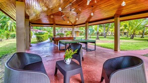 An outdoor covered area with wooden ceiling, ceiling fans, and wicker furniture. - Beachfront Studio 3, Playa Palo Seco (Parrita)