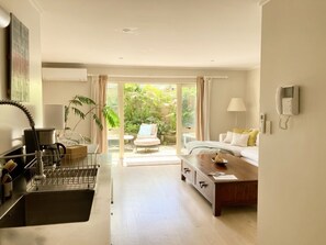 Una habitación de hotel moderna con cocina, una mesa de comedor y un sofá.