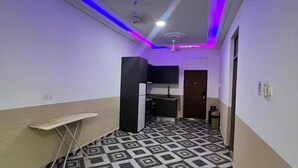 A narrow hallway with a patterned floor, a small table, a black cabinet, a ceiling fan, and a door at the end. - 5 Bedroom House Sleeps 12 -Balcony -Hired security (Accra)