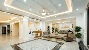 A spacious lobby with a reception desk, a patterned floor, and a seating area with sofas and a coffee table. - Dolce Mia Home Ninh Binh (Ninh Binh)
