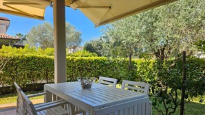 An outdoor patio with a table and chairs, surrounded by greenery and a clear sky. - Villa Roberta - Modern independent villa (Marina di Casal Velino)