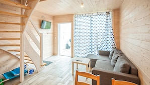 A wooden interior with a staircase, a sofa, a table, and a TV mounted on the wall. - Beautiful home in Sarbinowo with WiFi (Sarbinowo)
