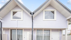 A two-story house with a gable roof, a central chimney, and a garage door. - Beautiful home in Sarbinowo with WiFi (Sarbinowo)