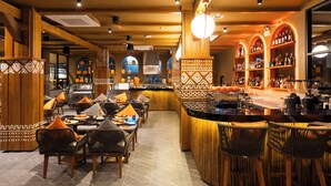 A restaurant with a bar area, wooden furniture, and patterned decor. - 79 Beach Club and Resort Samui (Koh Samui)