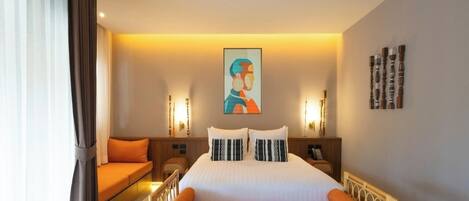 Una habitación de hotel con una cama, un sofá, un cuadro y una mesita de noche.
