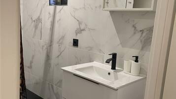 Een douche, een haardroger, een bidet, handdoeken