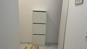 Ein Flur mit einem weißen Schrank, einem Streifen Teppich und Marmorboden.