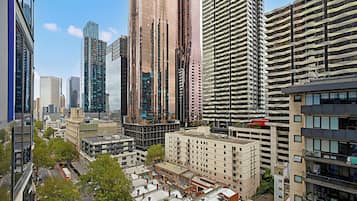 A cityscape with modern high-rise buildings, a mix of residential and commercial structures, and a clear sky.
