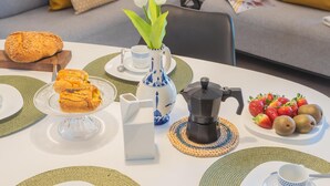 A dining table set with plates, cups, a coffee pot, and food items. - Ponente Balcony Garden (Gravedona)