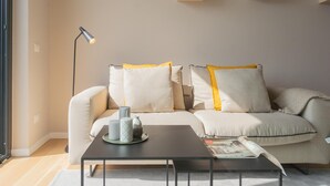 Een moderne woonkamer met een bank, een salontafel en een vloerlamp.