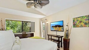 A bedroom with a bed, a TV, a desk, and a window with a view of greenery. - New! Downtown Zen Oasis: Best Value, 2 Patios (Palm Springs)