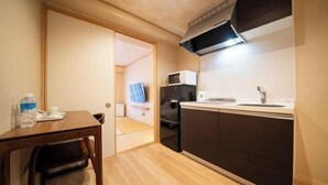 Une cuisine compacte équipée d’un four à micro-ondes, d’un réfrigérateur et d’un évier.