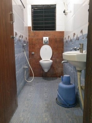 A small bathroom with a toilet, sink, and a blue water heater.