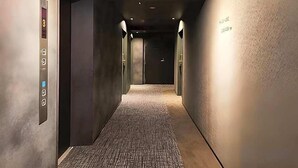 A hallway with an elevator, a security camera, and a wall with a sign. - Kyoto Gion Hotel (Kyoto)