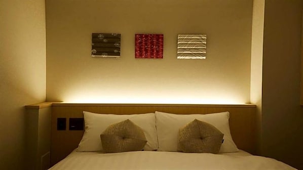 A hotel room with a bed, two pillows, and three wall-mounted artworks. - Kyoto Gion Hotel (Kyoto)