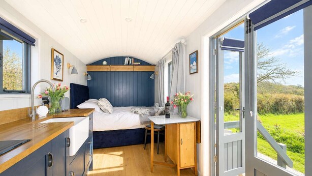Een slaapkamer met een bed, nachtkastje en een raam.