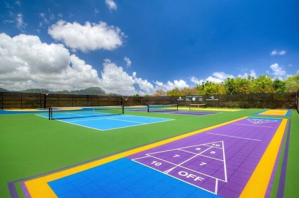 Ein Mehrsporthof mit einer Rumpelplatzfläche, Tennisplätzen und einem Basketballfeld.