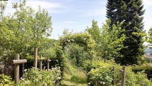 A garden pathway with wooden posts and flowering plants. - Holiday Home 'Gästehaus Altes Forstamt Sinntal' with Mountain View, Terrace and Wi-Fi (Sinntal)