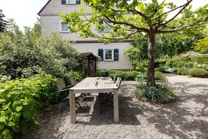 A house with a gravel patio, a wooden table, and chairs. - Holiday Home 'Gästehaus Altes Forstamt Sinntal' with Mountain View, Terrace and Wi-Fi (Sinntal)