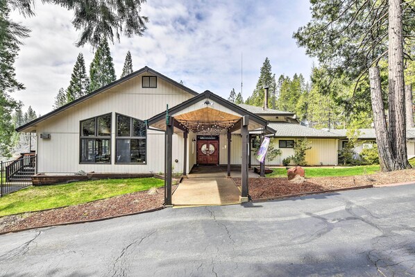 A modern two-story house with a covered porch, large windows, and a well-maintained lawn.