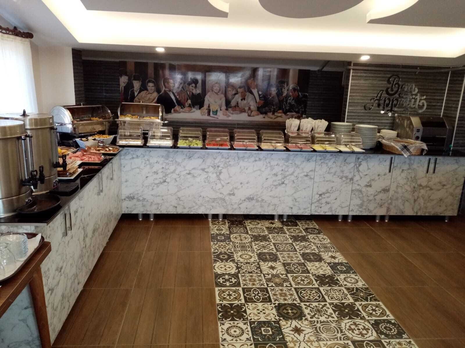 A buffet area with various food options, a marble counter, and a patterned rug.