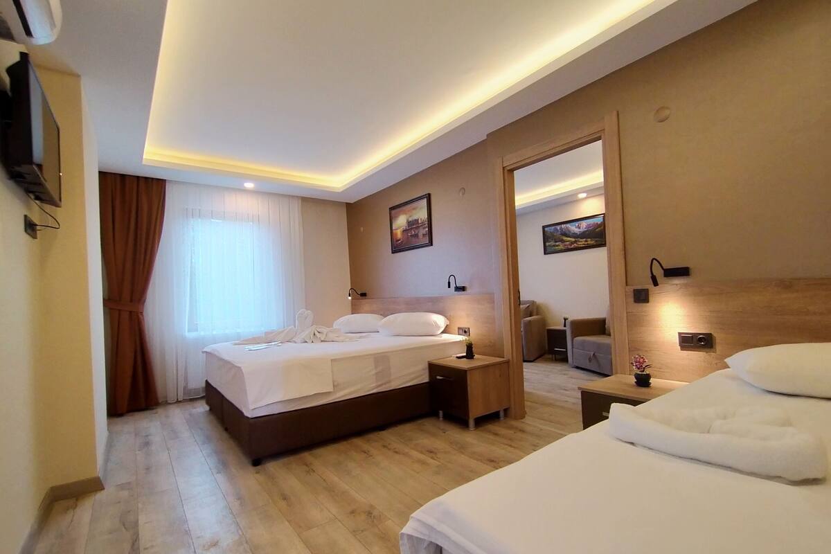 Een hotelkamer met een groot bed, nachtkastjes, een bureau en een stoel.