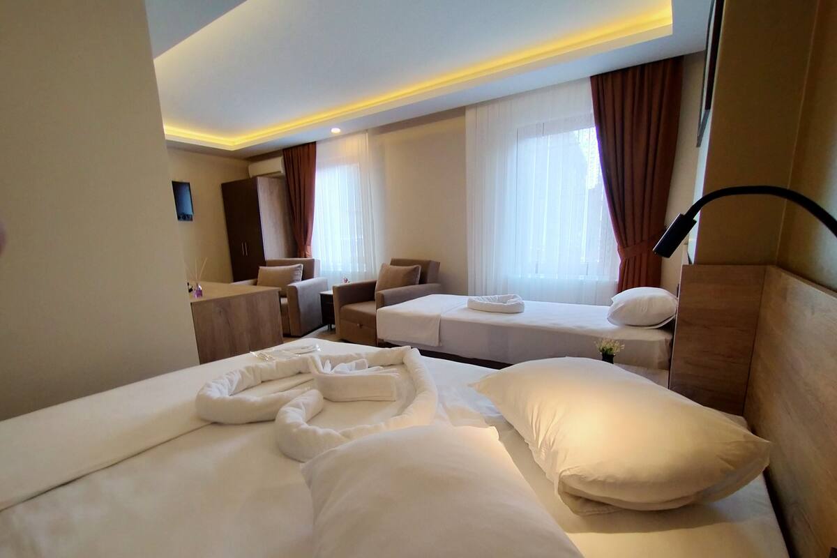 Een hotelkamer met twee bedden, een bureau en een stoel.