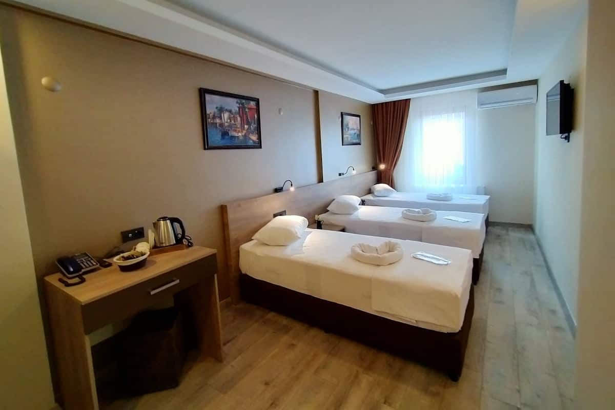 Een hotelkamer met twee bedden, een bureau, een telefoon en een koffiezetapparaat.