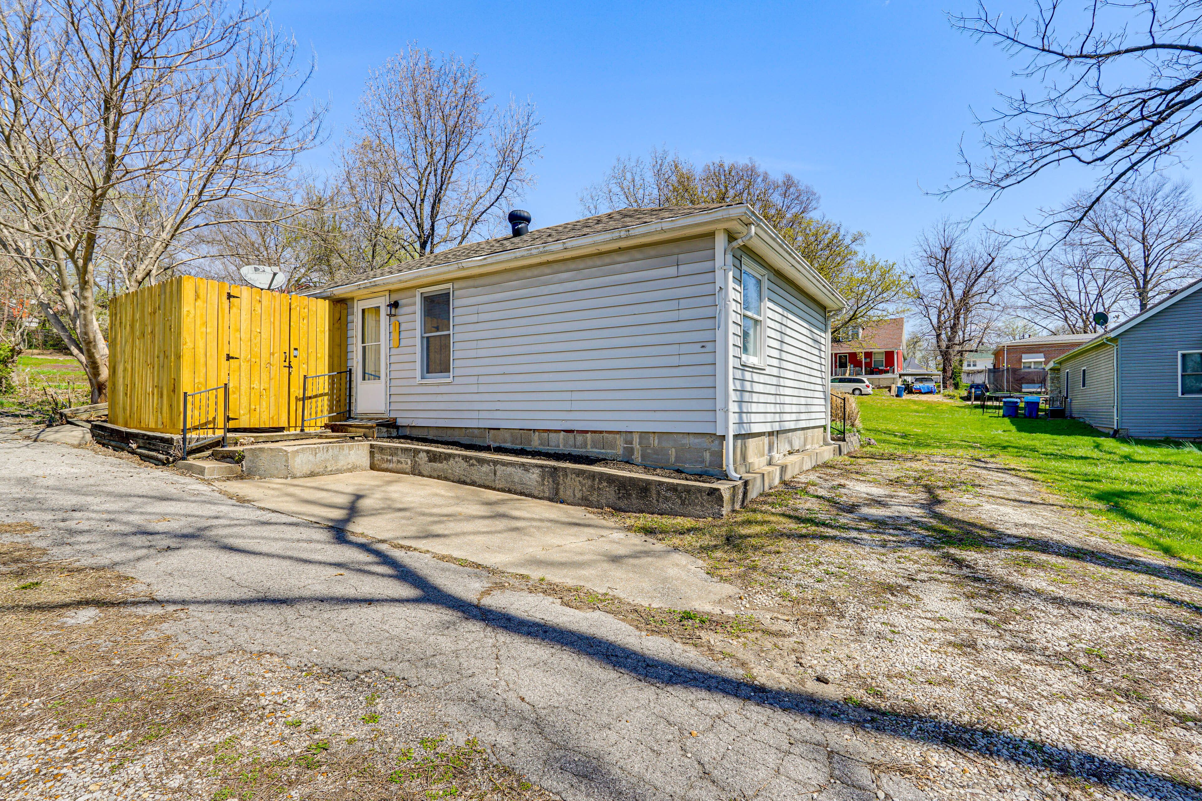 A single-story mobile home with a small porch and a fenced yard.